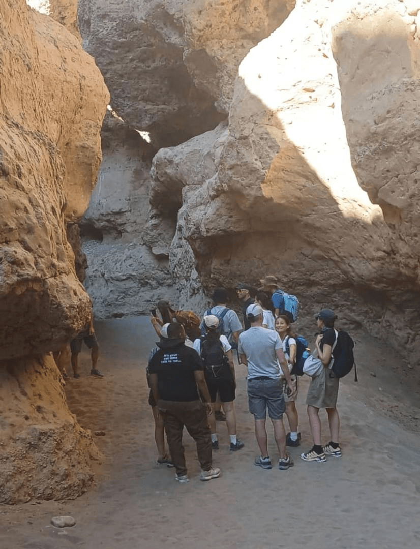 Travelers exploring ancient rock formations with guide